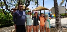 A family wearing protective sun gear and following Maui beach safety tips.