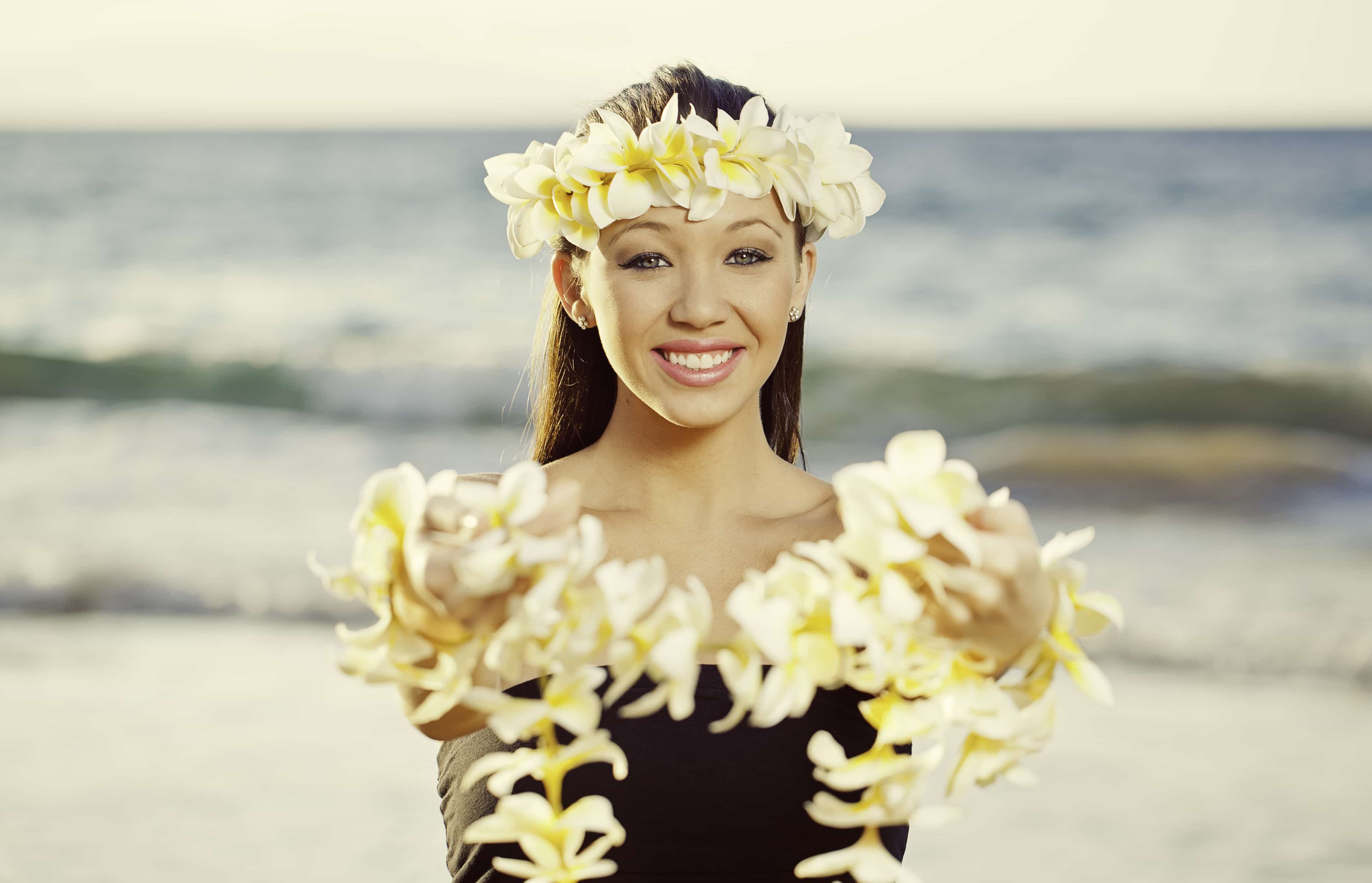 hawaiian girl holds lei on beach