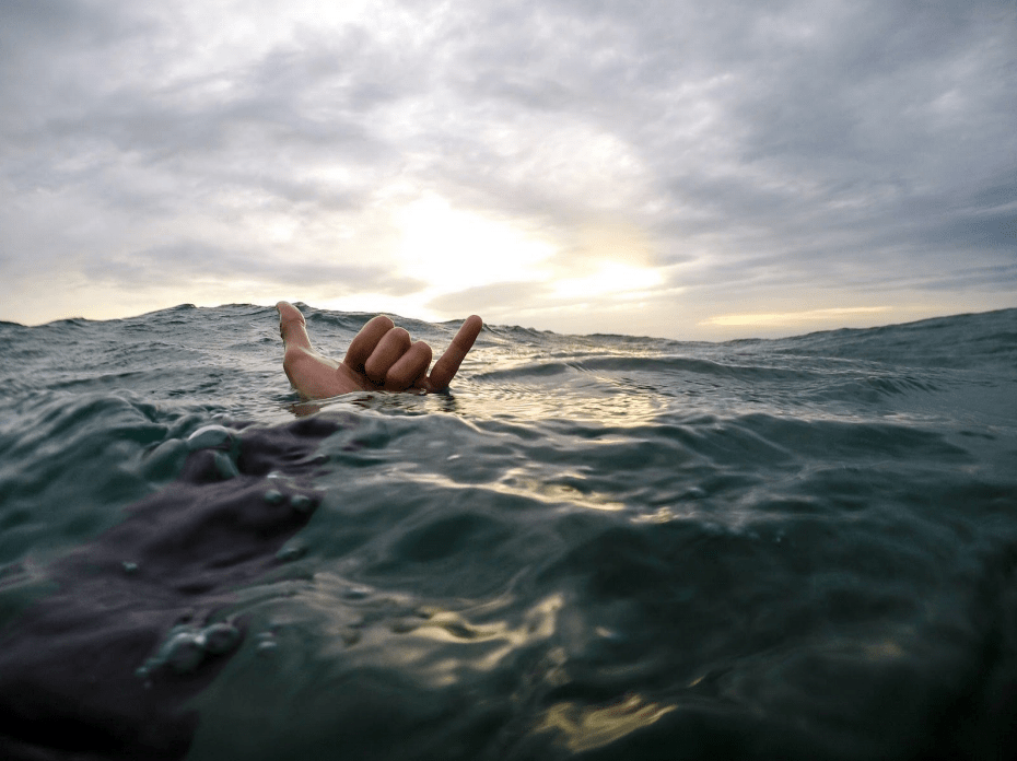 hawaiian swimming shaka at sunset